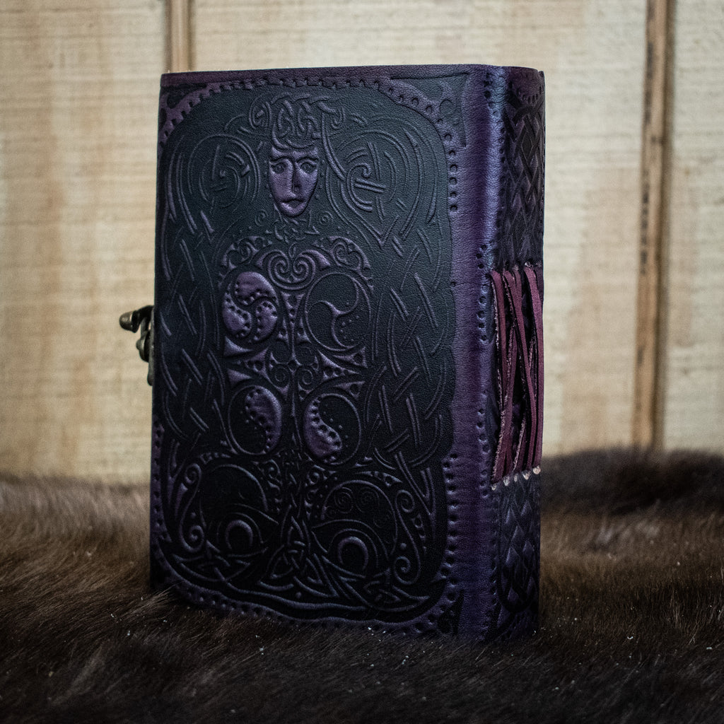 A purple leather journal featuring an owl and a woman