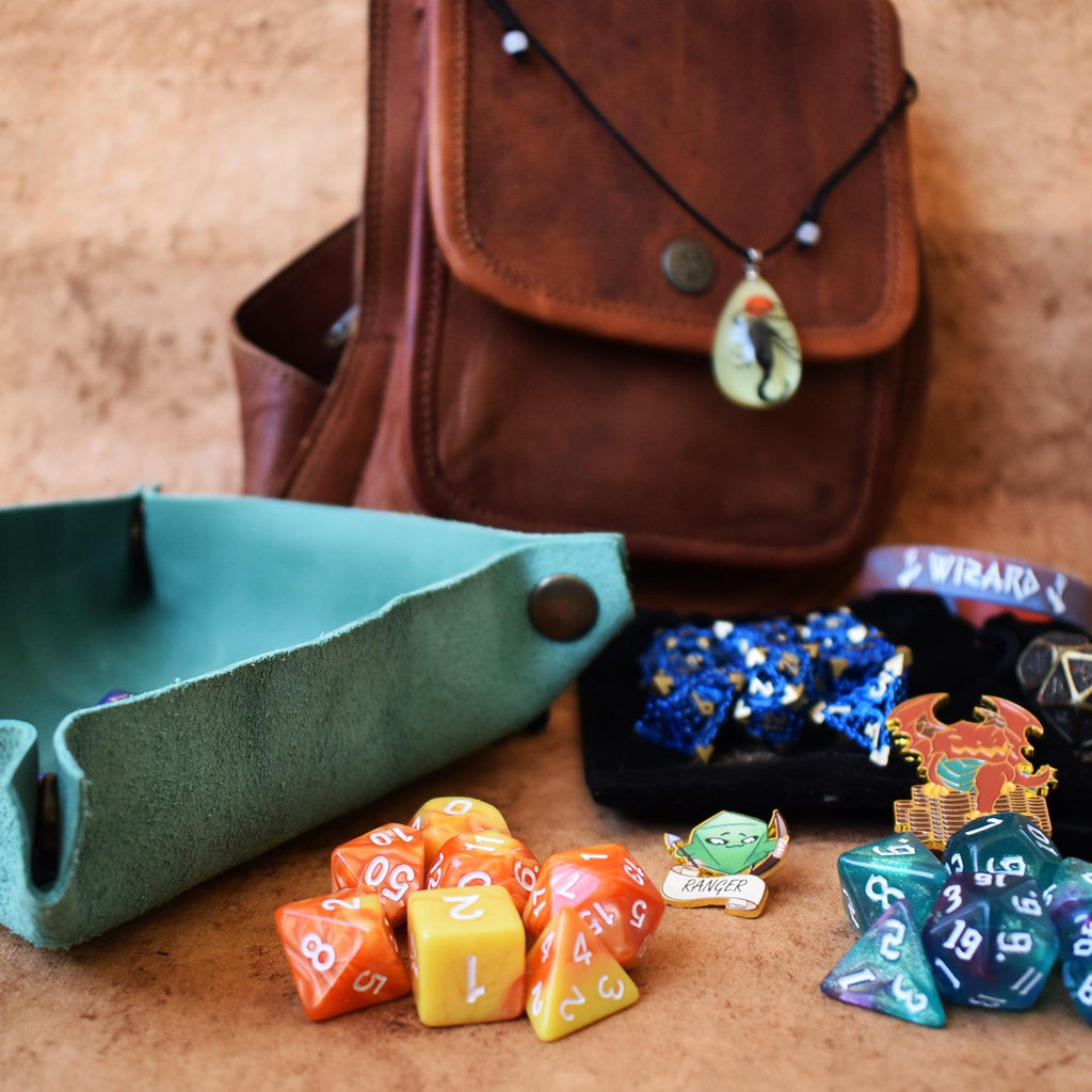 A brown leather sling mystery dice bag with examples of the items within