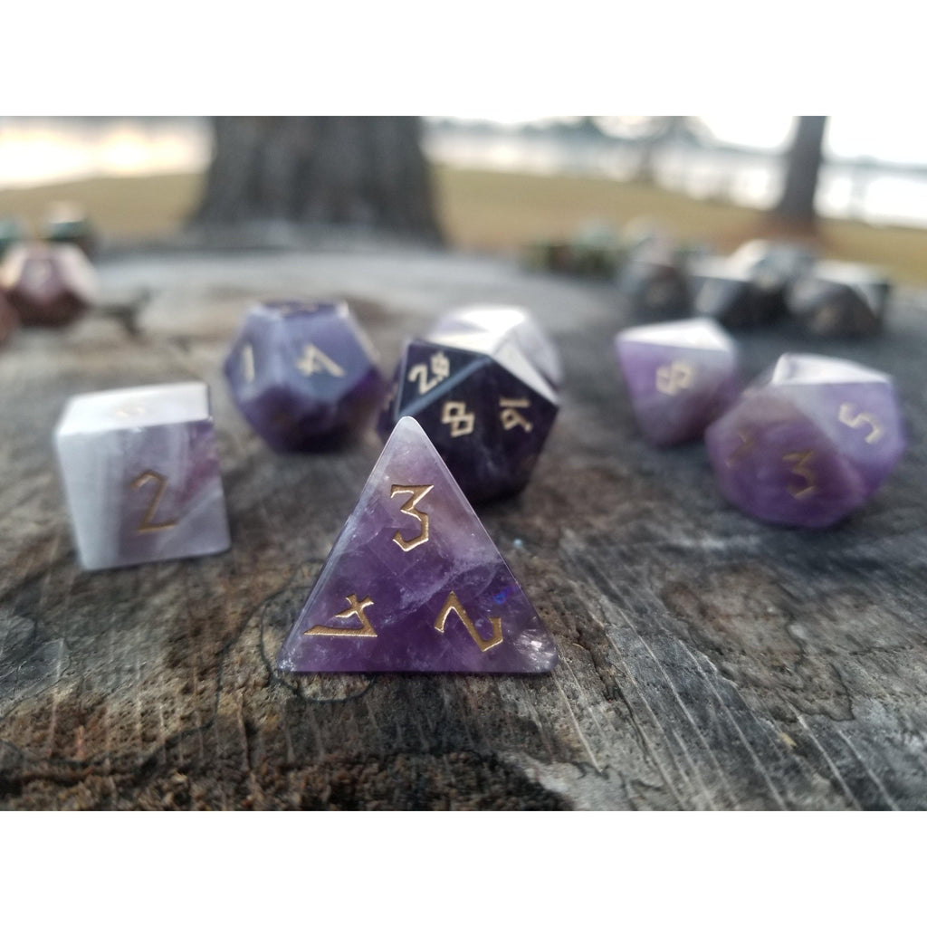 An amethyst stone dice set featuring gold numbers in a Nordic font