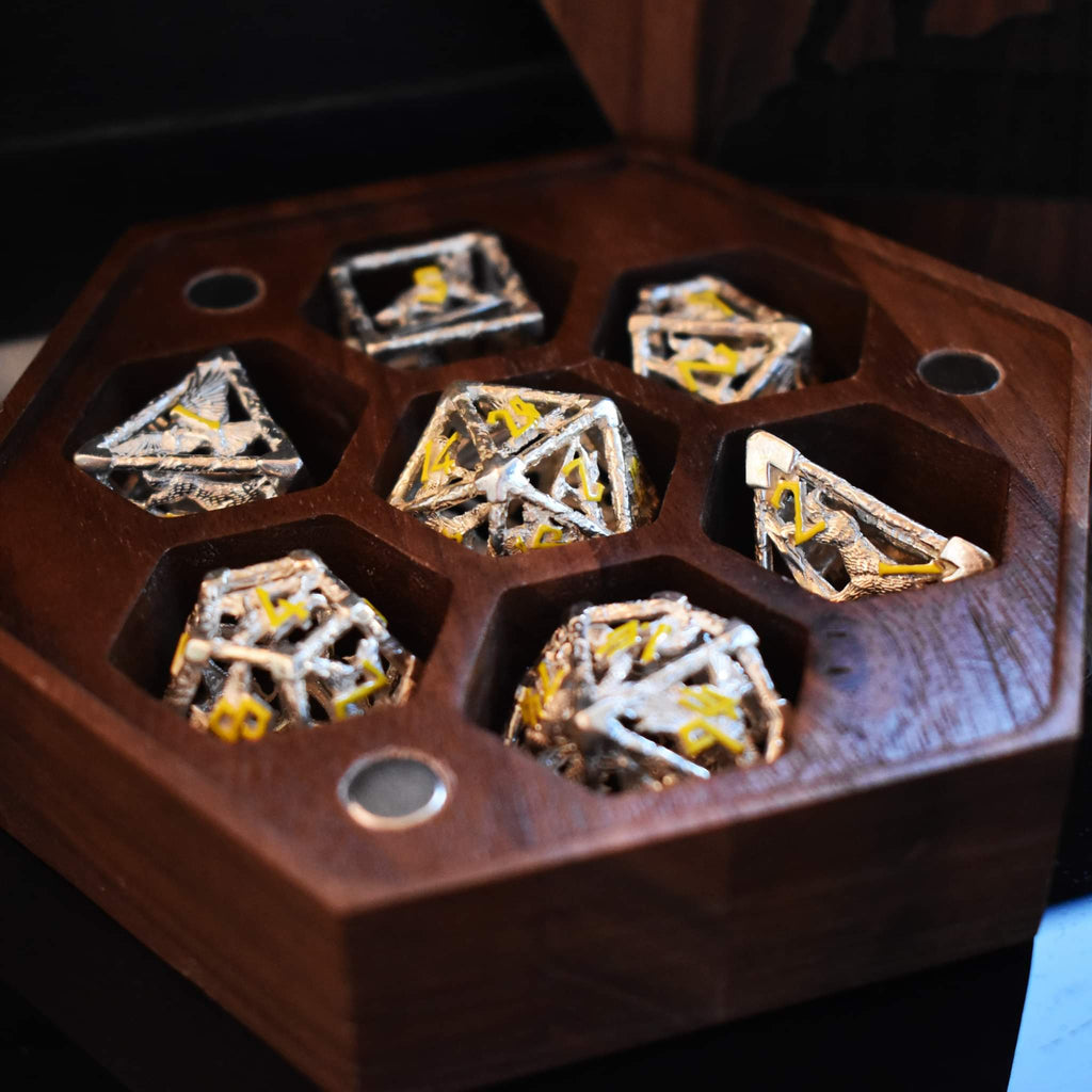 A hollow sterling silver dice set with yellow Nordic font numbers inside of a wooden dice case featuring a wolf