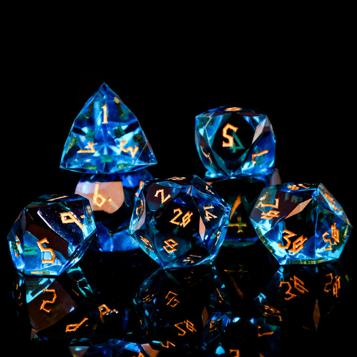 Set of blue polyhedral dice with orange numbers on a black background