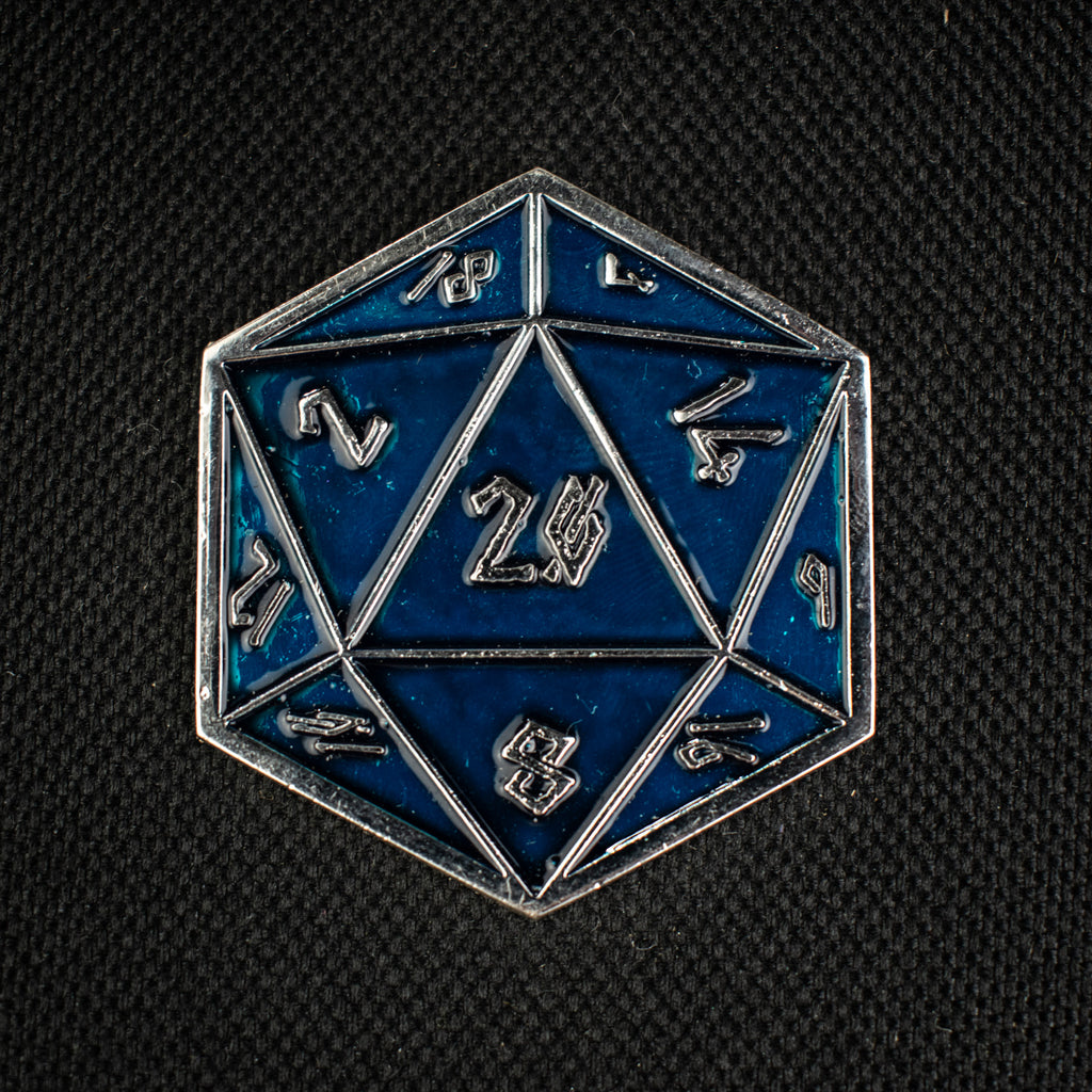 An aqua D20 pin with silver numbers in a Nordic font