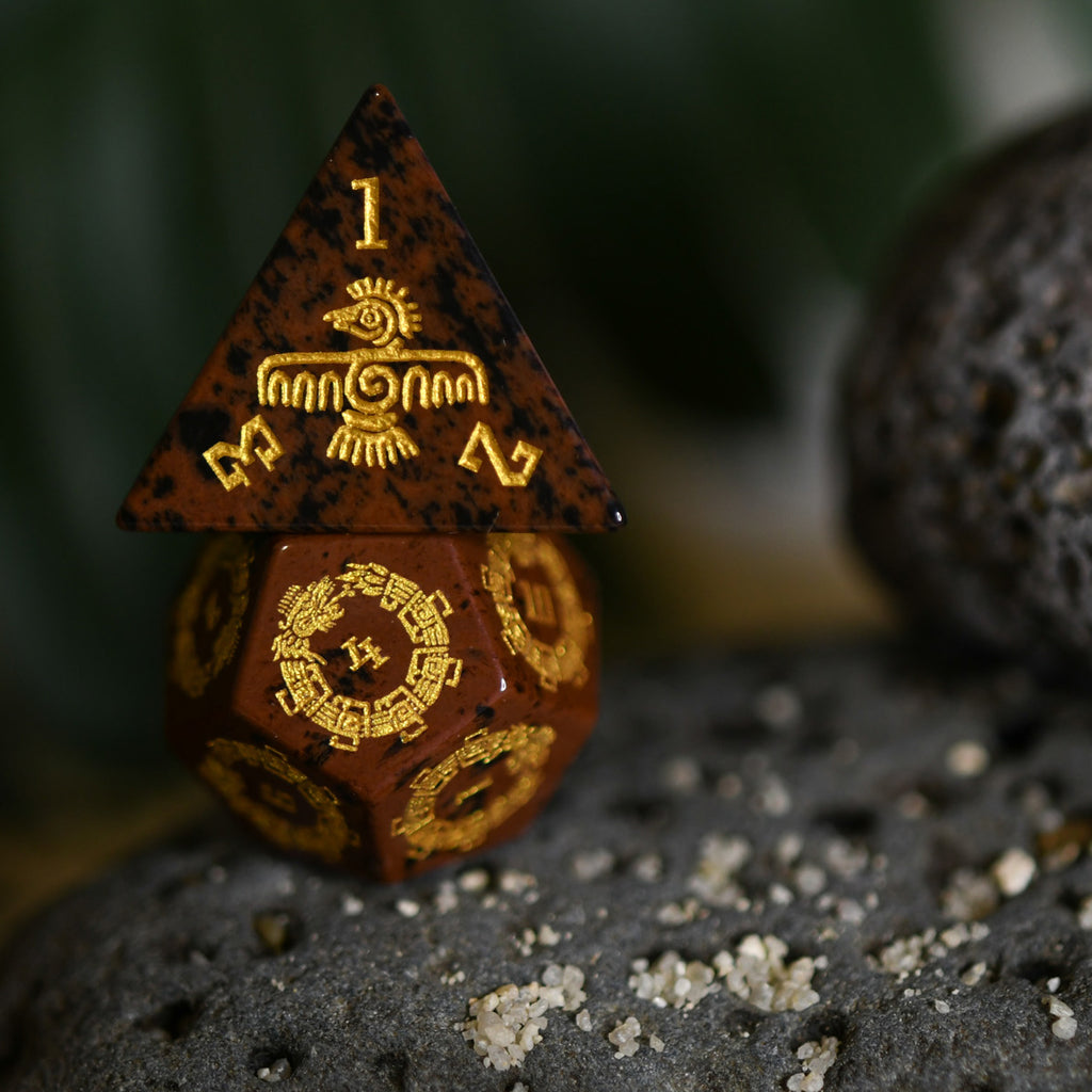 A set of hand-carved, Aztec Mahogany Obsidian Stone Dice with intricate Aztec designs