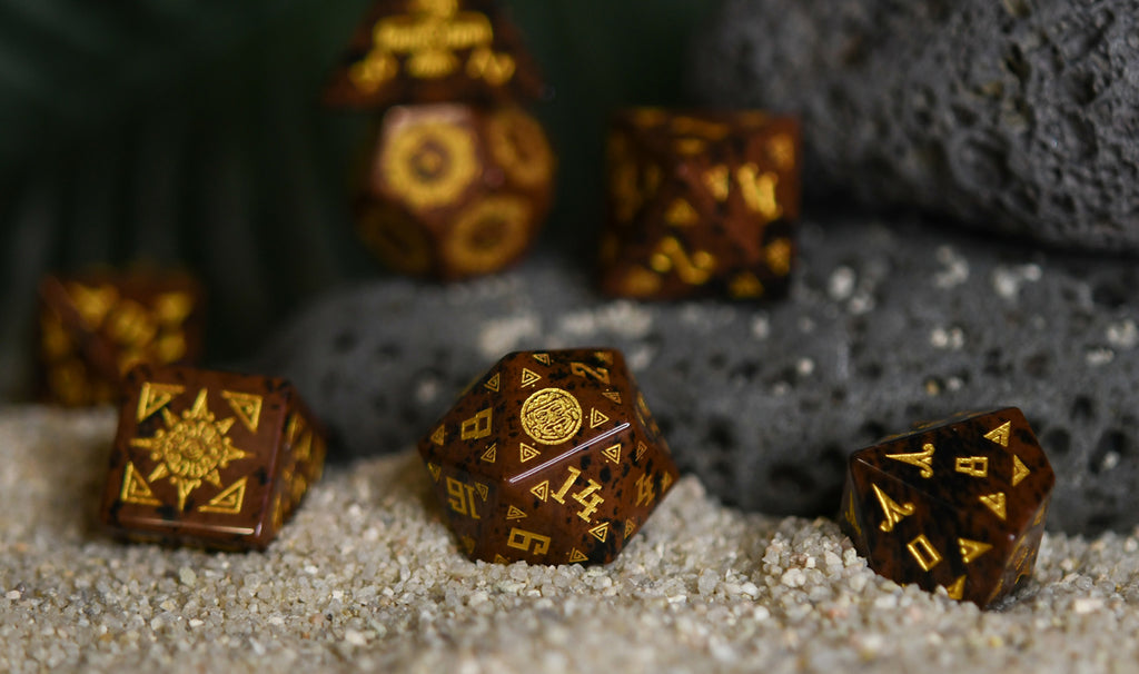 A set of hand-carved, Aztec Mahogany Obsidian Stone Dice with intricate Aztec designs