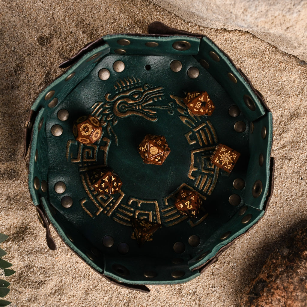 A set of hand-carved, Aztec Mahogany Obsidian Stone Dice with intricate Aztec designs in a leather dice tray