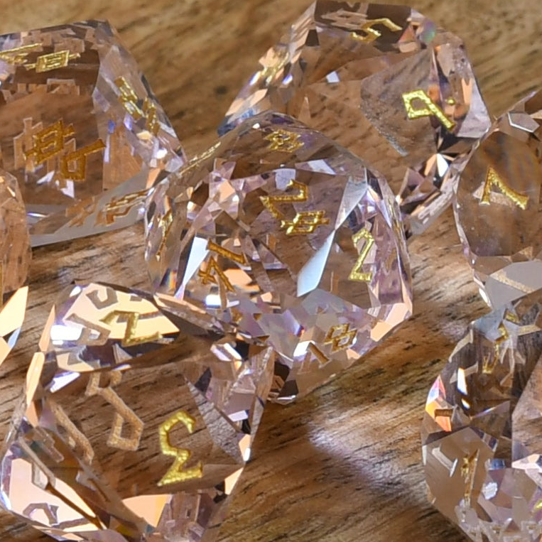 Crystal dice with gold lettering on a wooden surface
