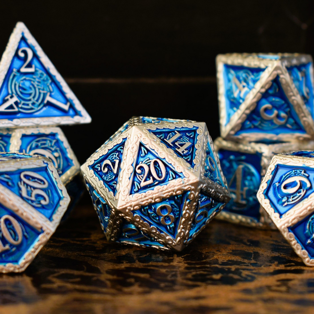 A set of blue and silver metal dice with musical note details around the silver numbers on a wooden surface, including various shapes such as a d4, d6, d8, d10, d12, and d20.