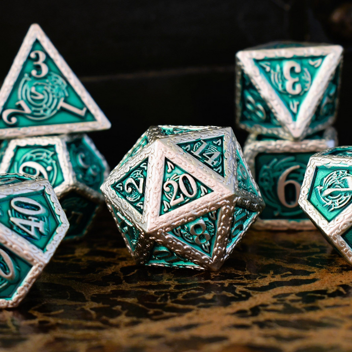 A set of green and silver metal dice with musical note details around the silver numbers on a wooden surface, including various shapes such as a d4, d6, d8, d10, d12, and d20.
