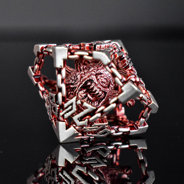A set of hollow metal dice in red and silver, including various shapes such as a d4, d6, d8, d10, d12, and d20, displayed on a reflective surface.