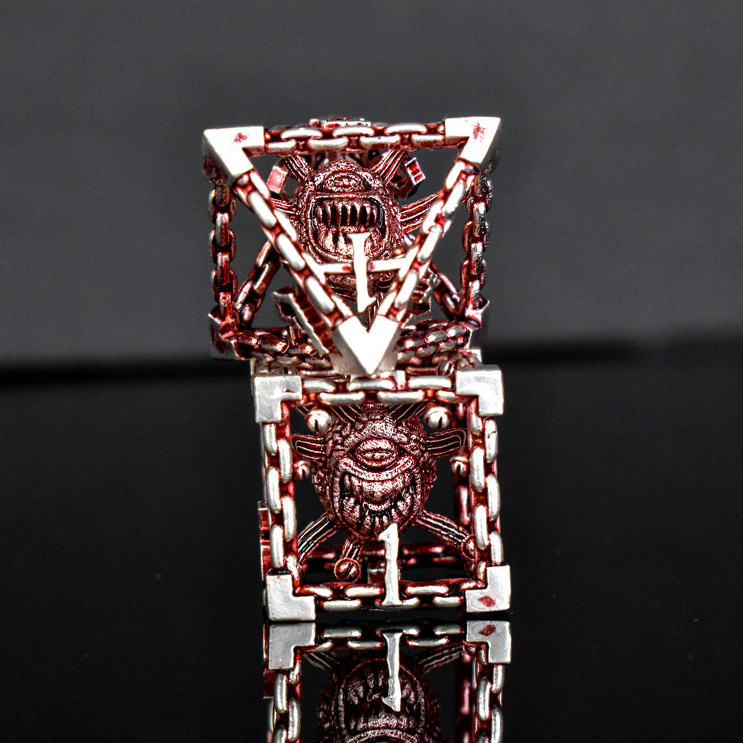 A set of hollow metal dice in red and silver, including various shapes such as a d4, d6, d8, d10, d12, and d20, displayed on a reflective surface.