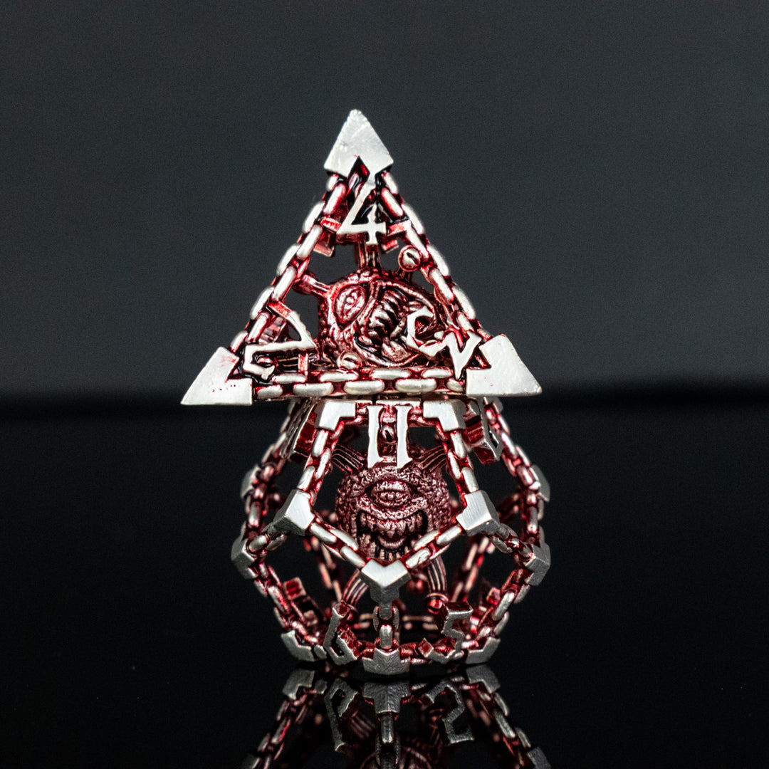 A set of hollow metal dice in red and silver, including various shapes such as a d4, d6, d8, d10, d12, and d20, displayed on a reflective surface.
