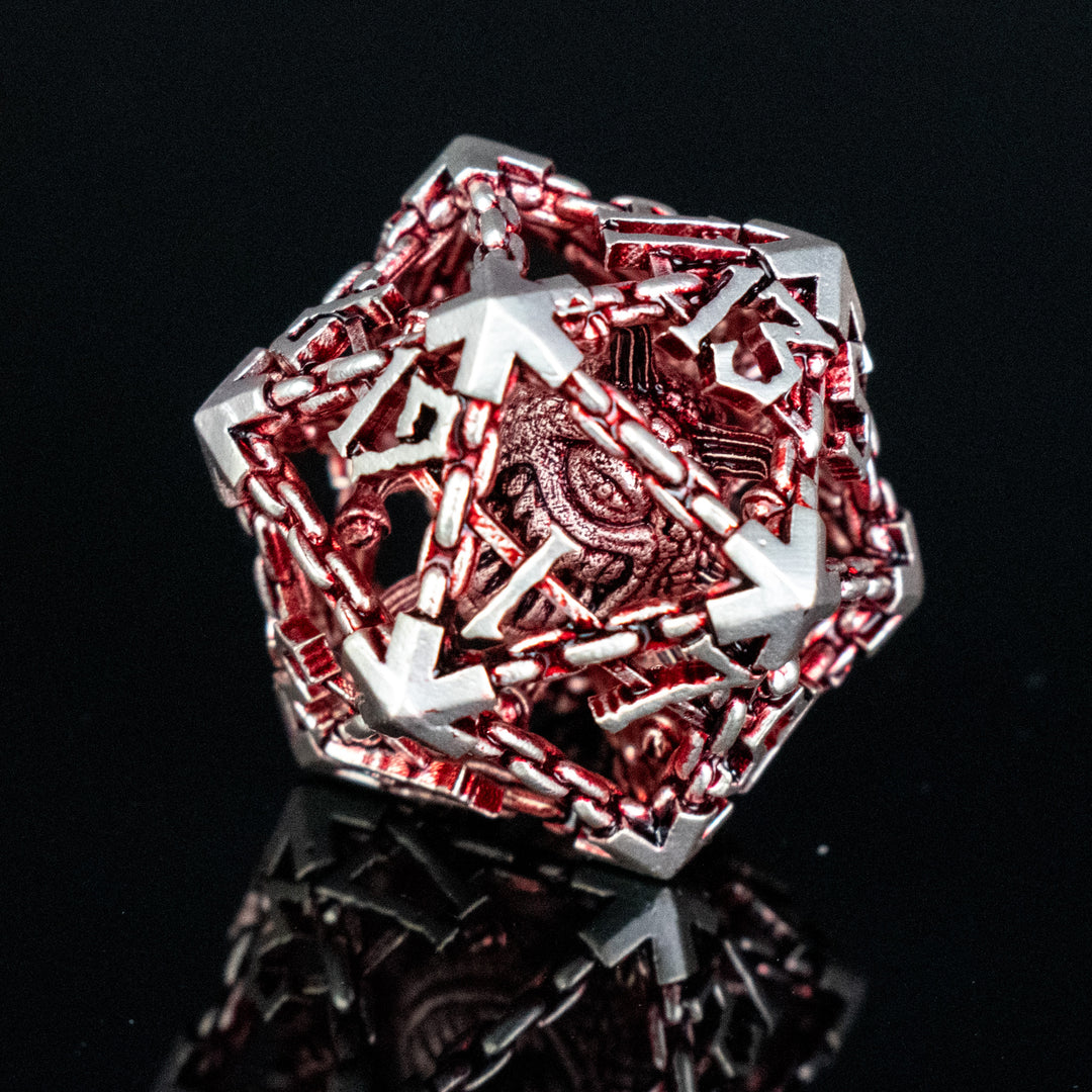 A set of hollow metal dice in red and silver, including various shapes such as a d4, d6, d8, d10, d12, and d20, displayed on a reflective surface.