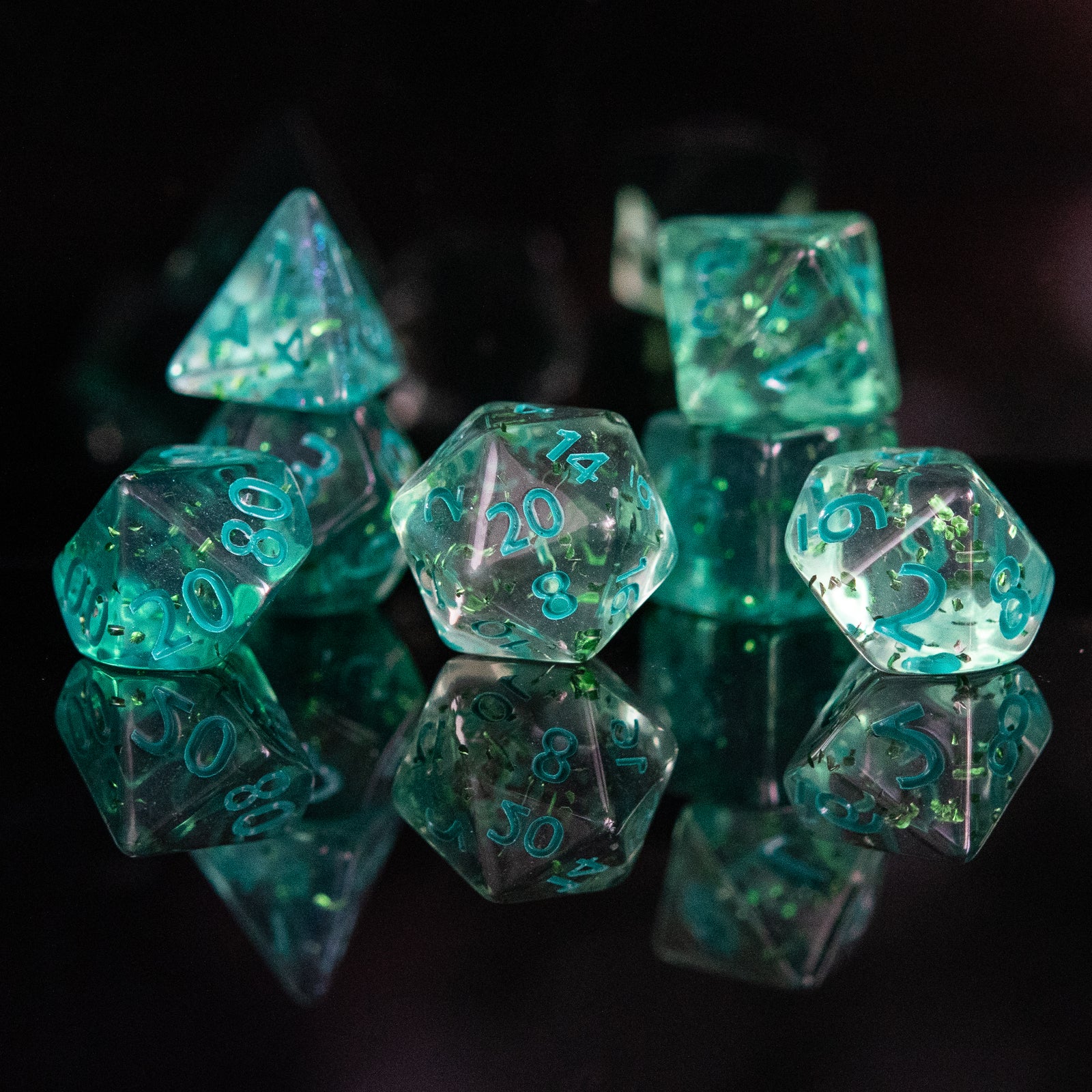 Green polyhedral dice with numbers on a reflective surface