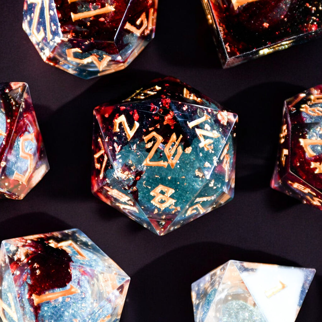 A set of hand-crafted, multicolored resin liquid core dice with engraved numbers, embedded with glitter, displayed on a dark background.