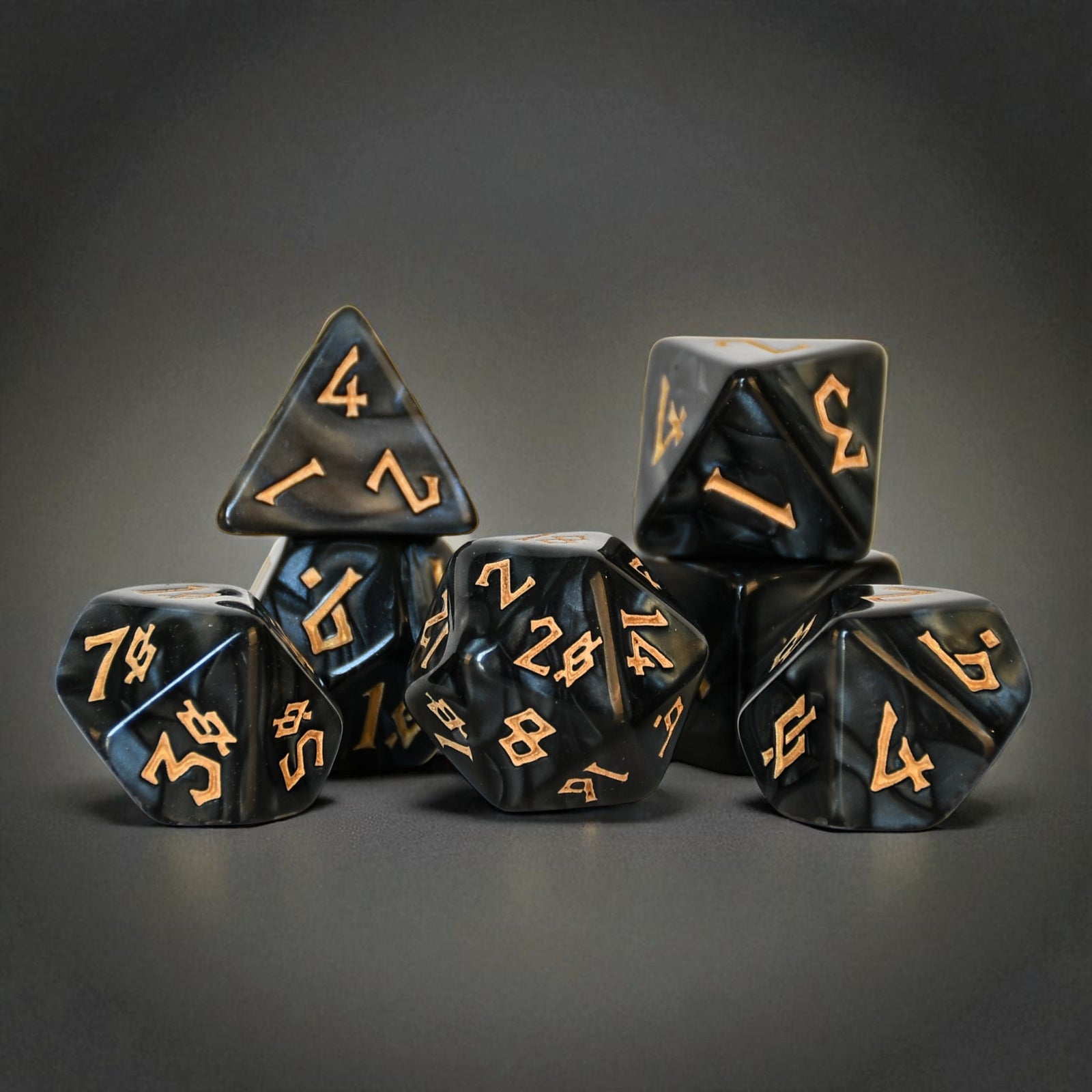A set of marble like black acrylic dice with gold nordic numbering font for tabletop gaming