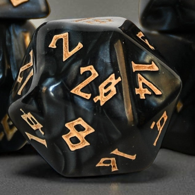 Black polyhedral dice with gold numbers on a gray background
