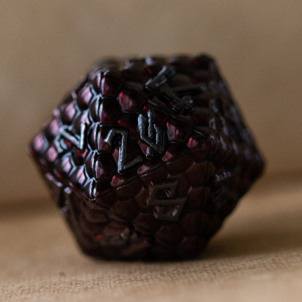 A set of metal dragons egg texture dice in dark red colors with embossed numbers, including various shapes such as a d4, d6, d8, d10, d12, and d20.