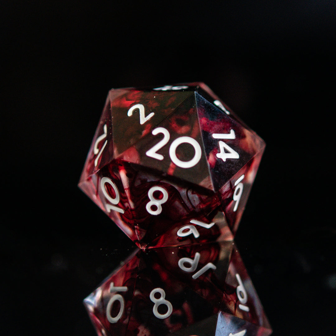 A set of polyhedral sharp edge resin clear dice with blood red running through and white numbering for tabletop games and board games