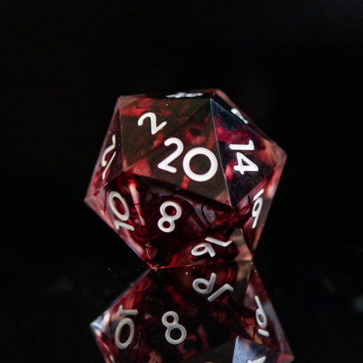 A set of polyhedral sharp edge resin clear dice with blood red running through and white numbering for tabletop games and board games