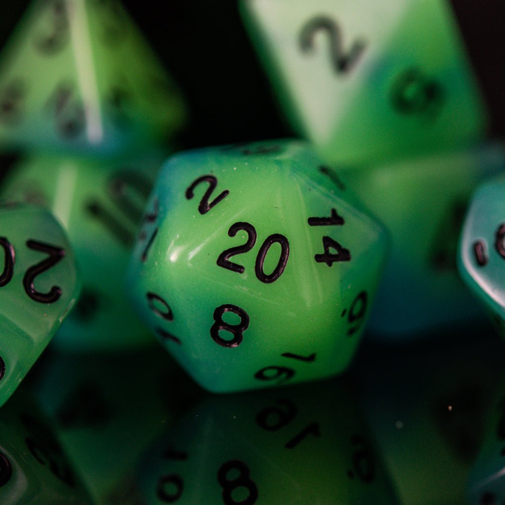 A set of green acrylic dice with black numbers, including various shapes typical for role-playing games.