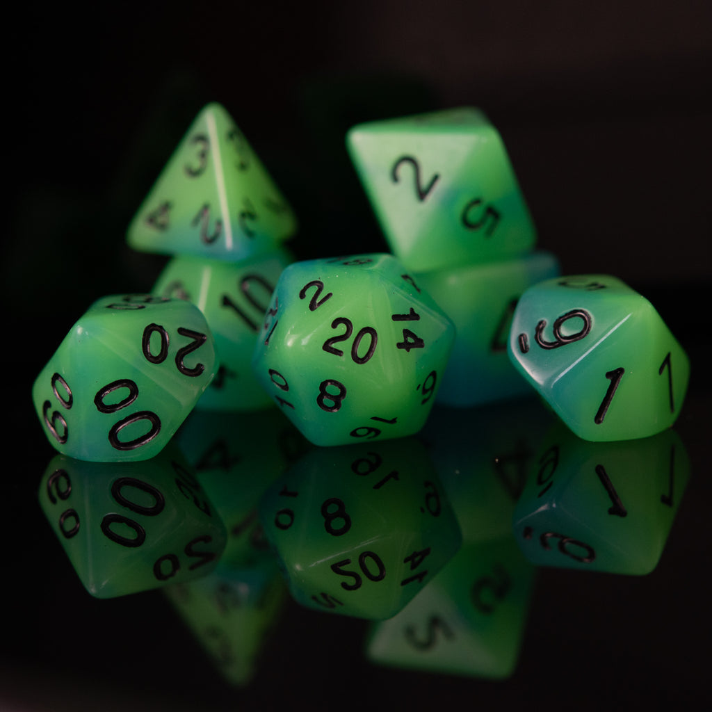 A set of green acrylic dice with black numbers, including various shapes typical for role-playing games.
