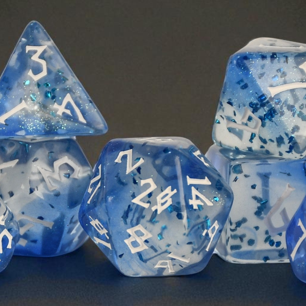 a set of white and blue acrylic dice with blue glitter chunks inside and white numbering for ttrpg