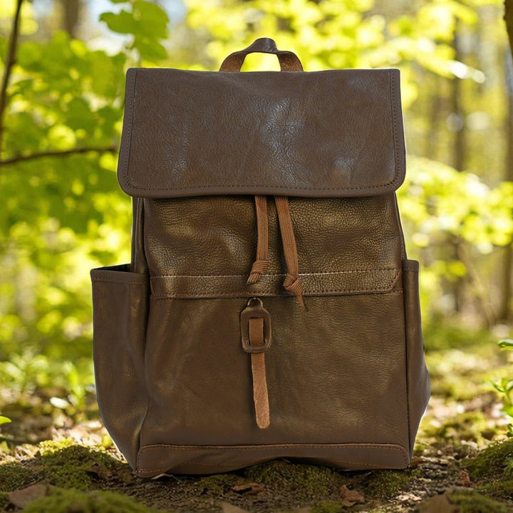 Brown leather modern rugged backpack in a forest setting