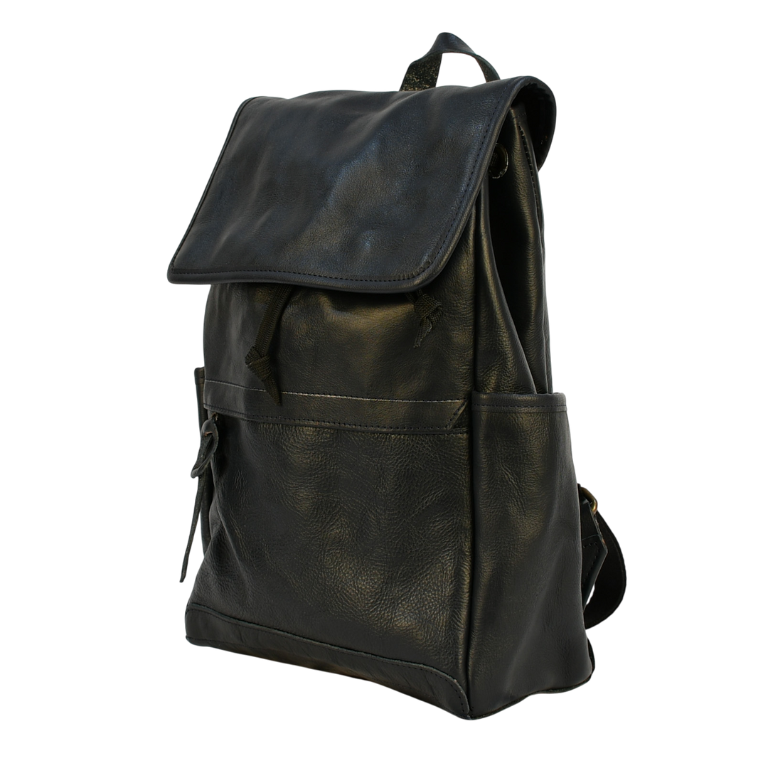 Dark leather navy modern rugged backpack on a wooden surface with books in the background