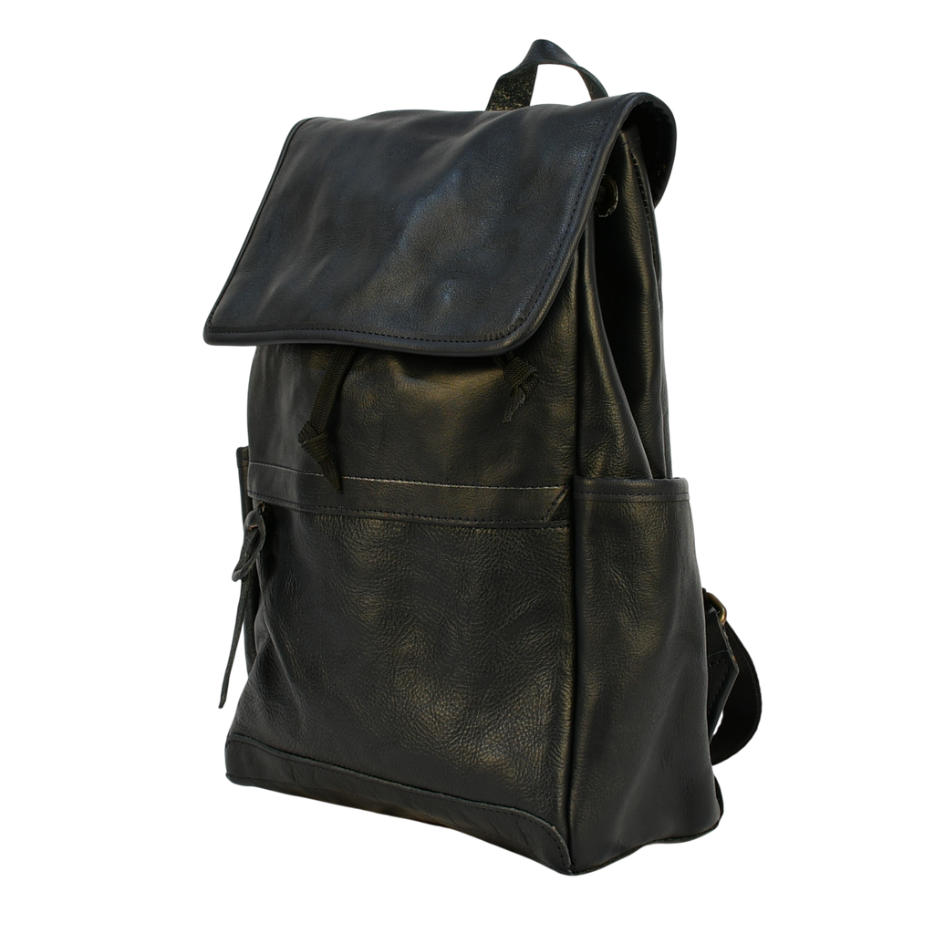 Dark leather navy modern rugged backpack on a wooden surface with books in the background