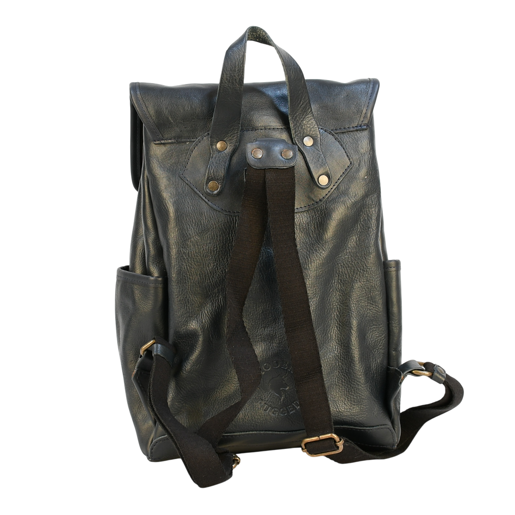 Dark leather navy modern rugged backpack on a wooden surface with books in the background