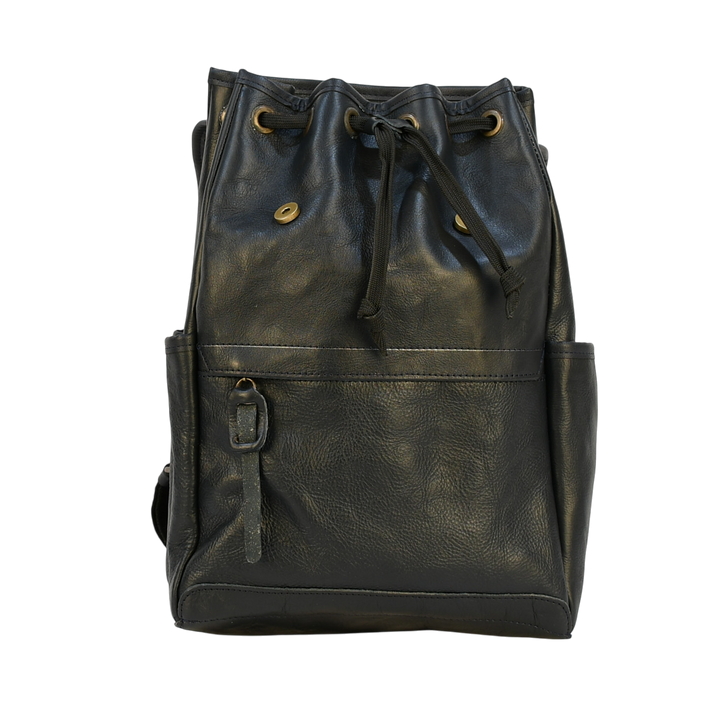 Dark leather navy modern rugged backpack on a wooden surface with books in the background