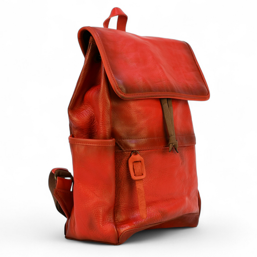 Red modern rugged leather backpack on a wooden surface
