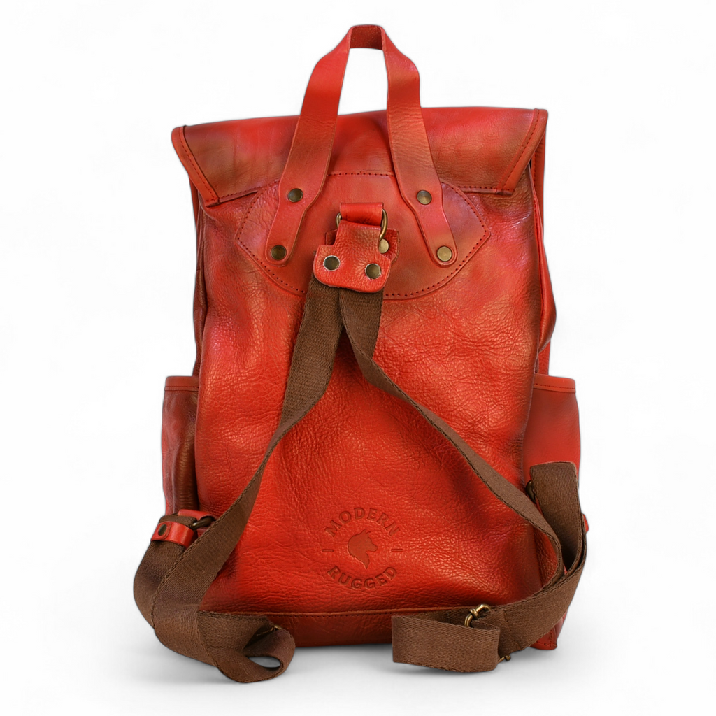 Red modern rugged leather backpack on a wooden surface