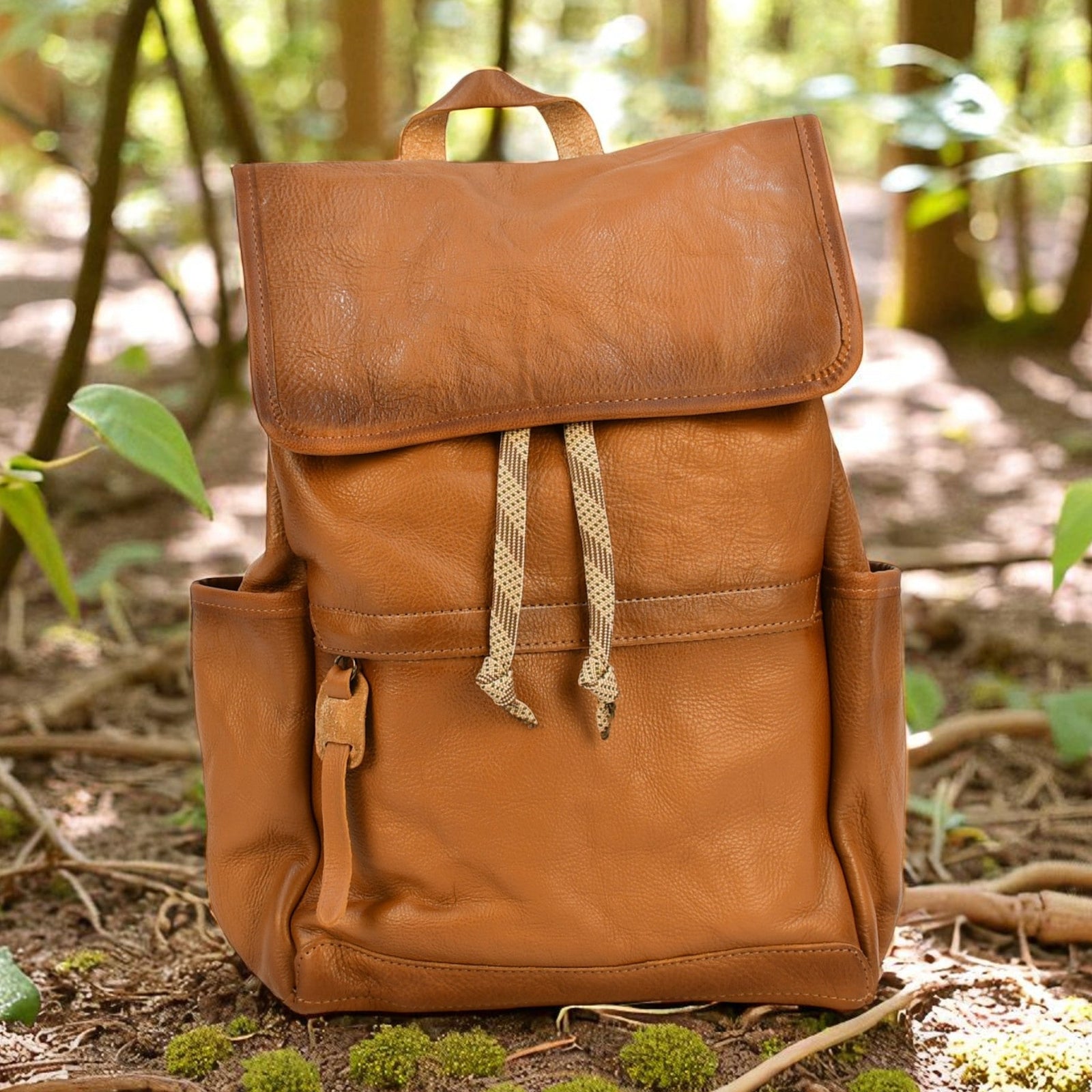 Brown leather modern rugged backpack on a forest floor