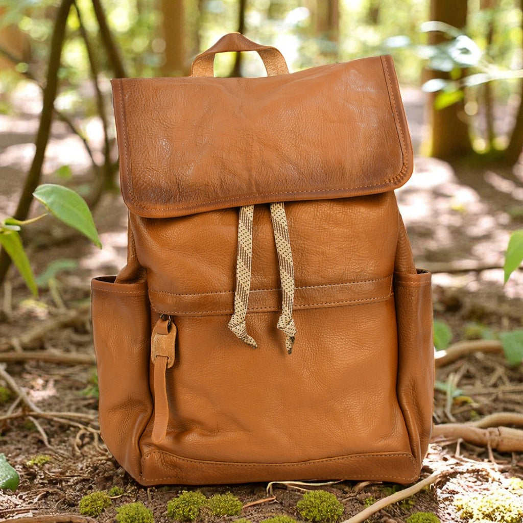 Brown leather modern rugged backpack on a forest floor