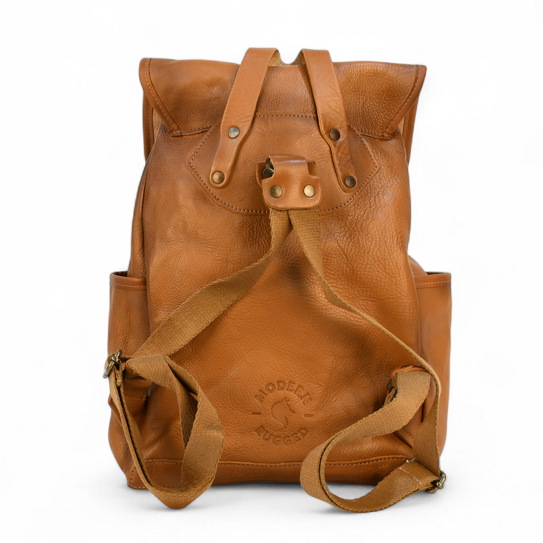 Brown leather modern rugged backpack on a forest floor