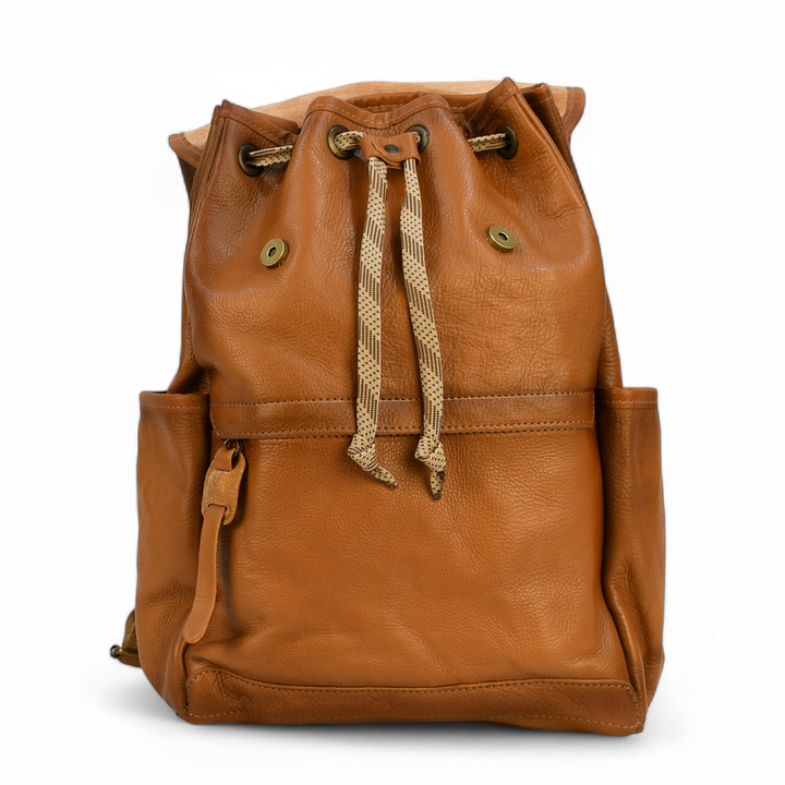 Brown leather modern rugged backpack on a forest floor
