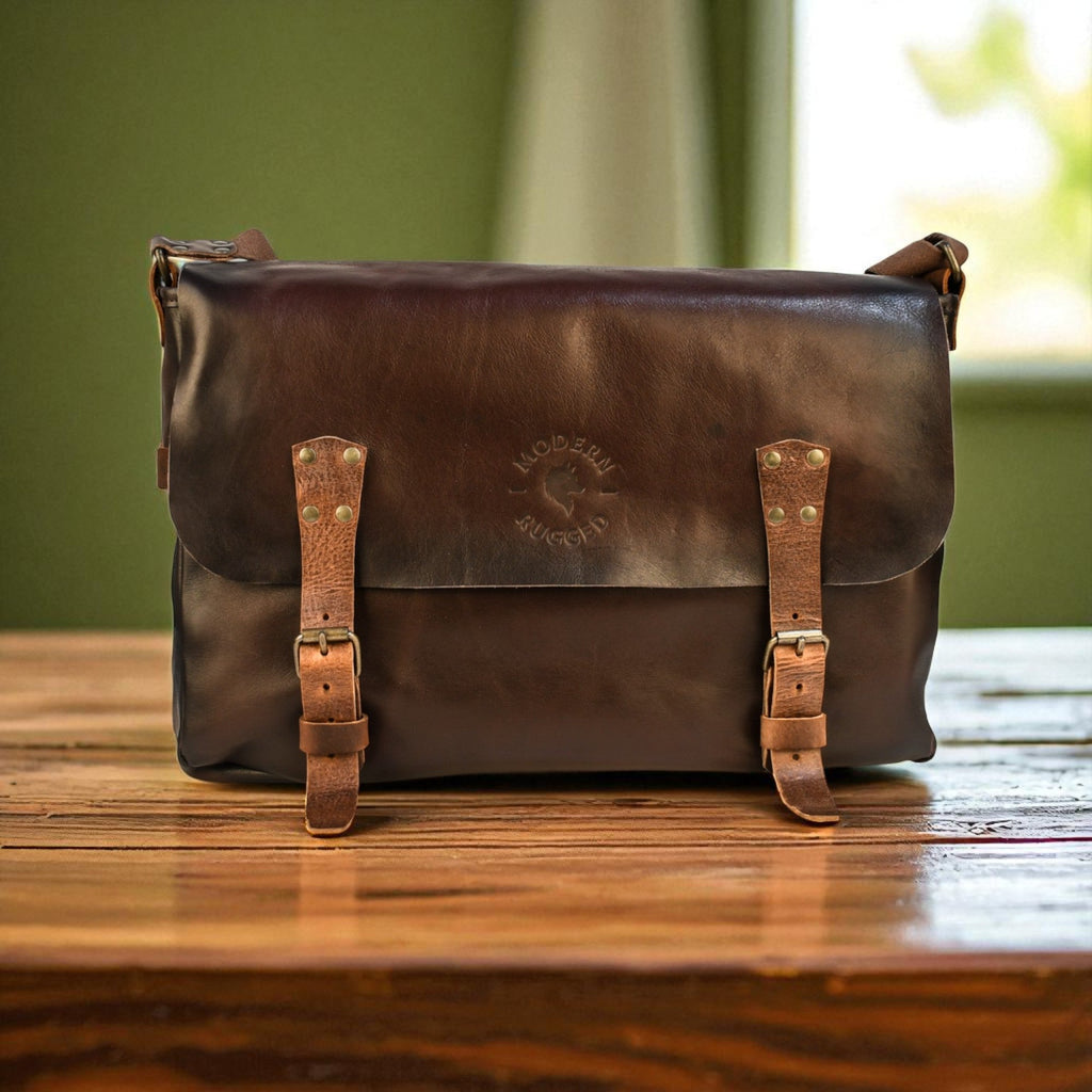 Brown leather bag with straps on a wooden surface
