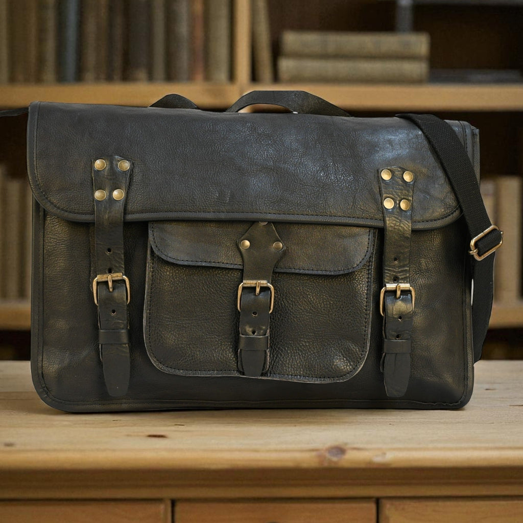 Vintage-style modern rugged leather briefcase bag on a wooden surface with bookshelf in the background