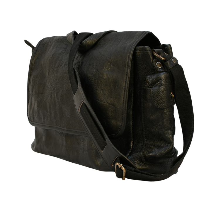 modern rugged black leather bag with a black strap on a stone pavement