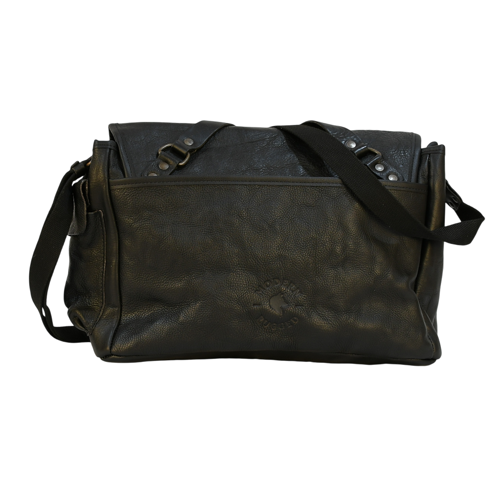 modern rugged black leather bag with a black strap on a stone pavement