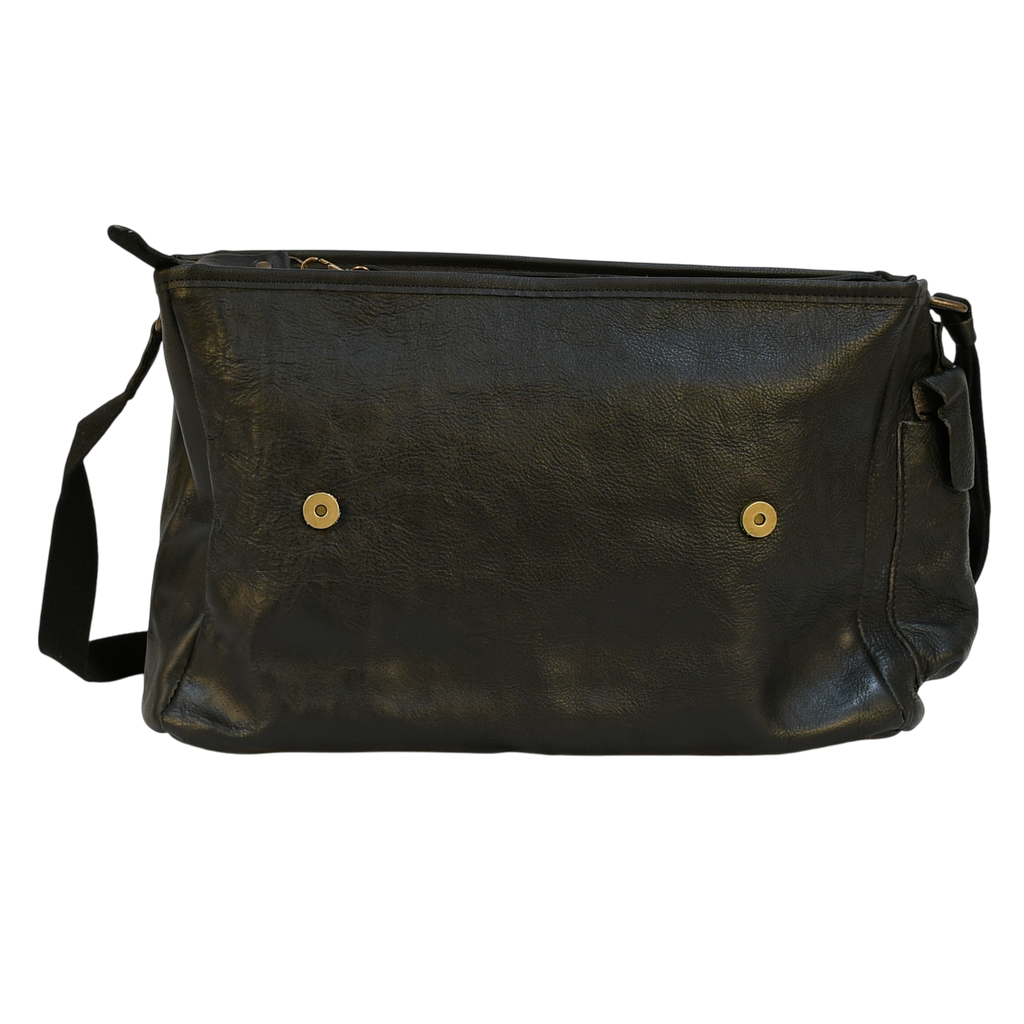 modern rugged black leather bag with a black strap on a stone pavement