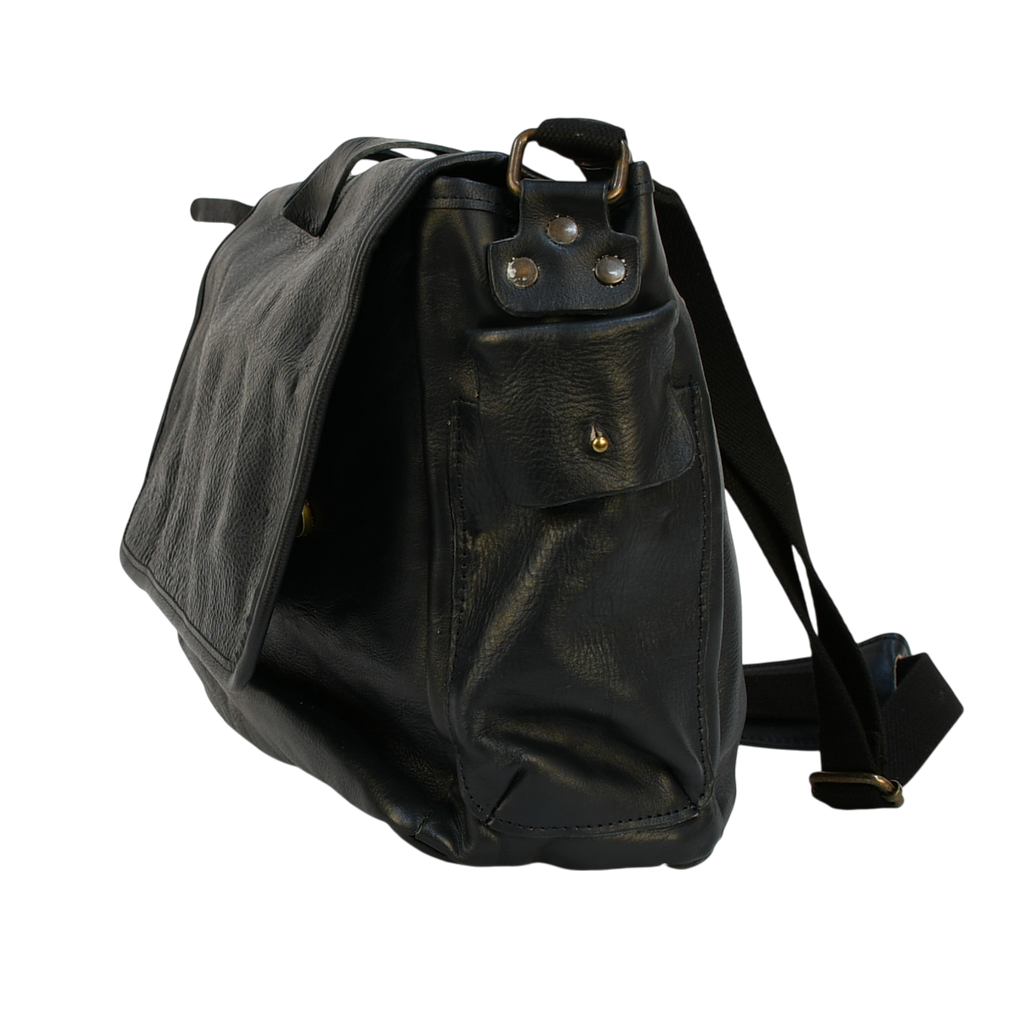 Navy leather modern rugged messenger bag on a wooden table with a gray background