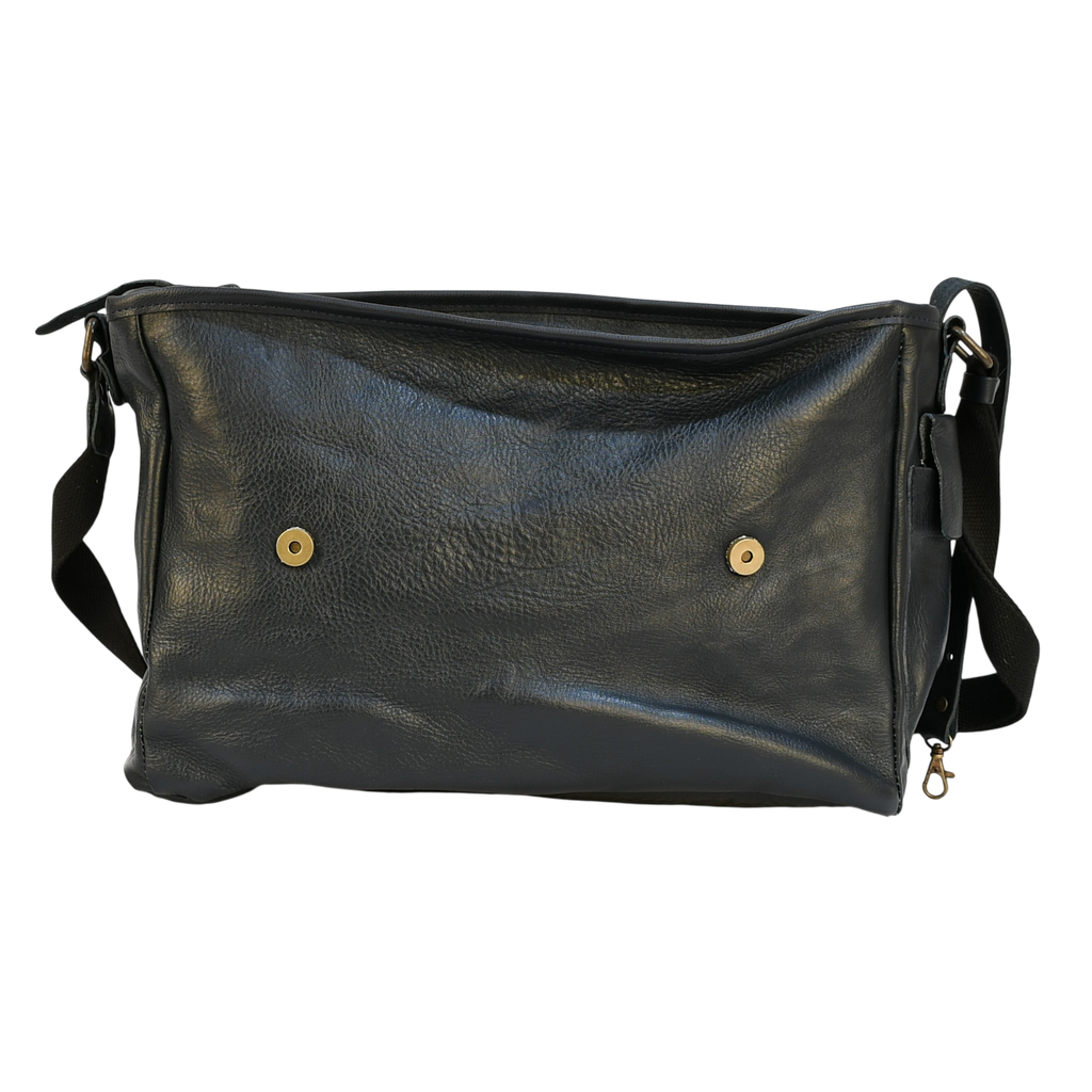 Navy leather modern rugged messenger bag on a wooden table with a gray background