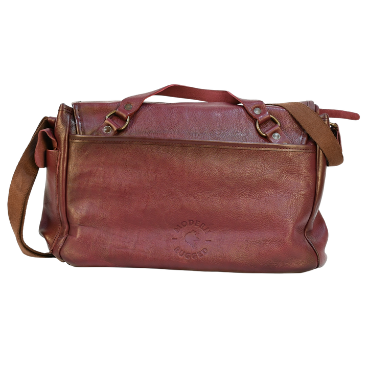 purple modern rugged leather messenger bag on a wooden table with a bookshelf in the background