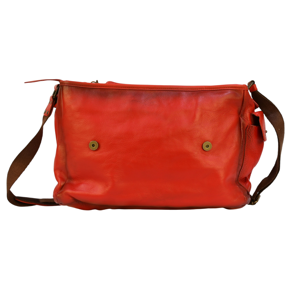 Red leather modern rugged messenger bag on a wooden surface with books in the background