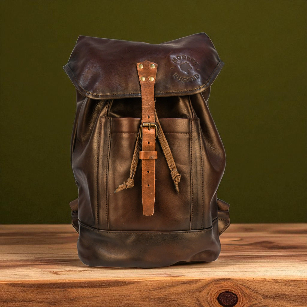 Brown leather backpack on a wooden surface with a green background