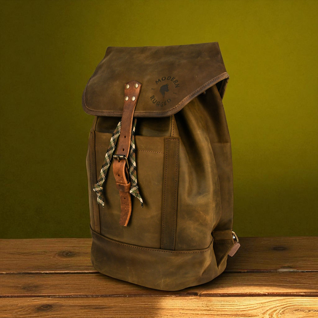 Brown leather backpack on a wooden surface with a green background