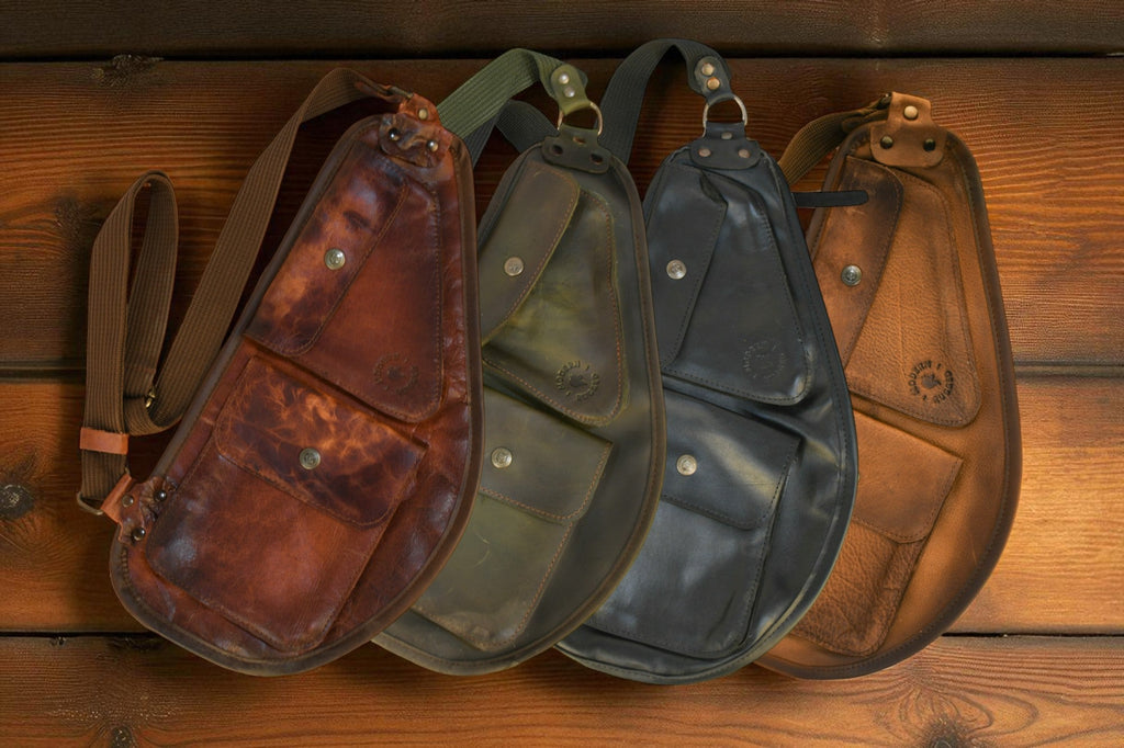 Four leather pouches in different colors arranged on a wooden surface.