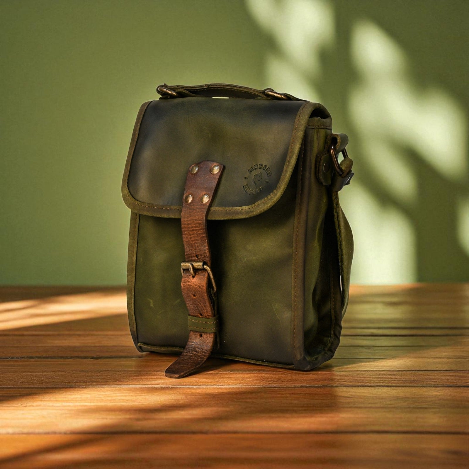 Green leather bag with brown strap on a wooden surface with a green background